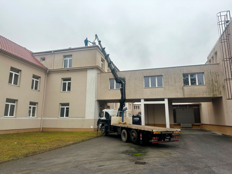 Autožeriav pri montážnych prácach na budove