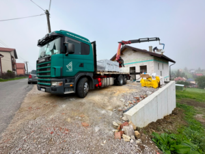 Nákladné vozidlo s hydraulickou rukou pri manipulácii s materiálom