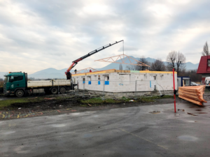 Autožeriav pri zdvíhacích prácach na budove
